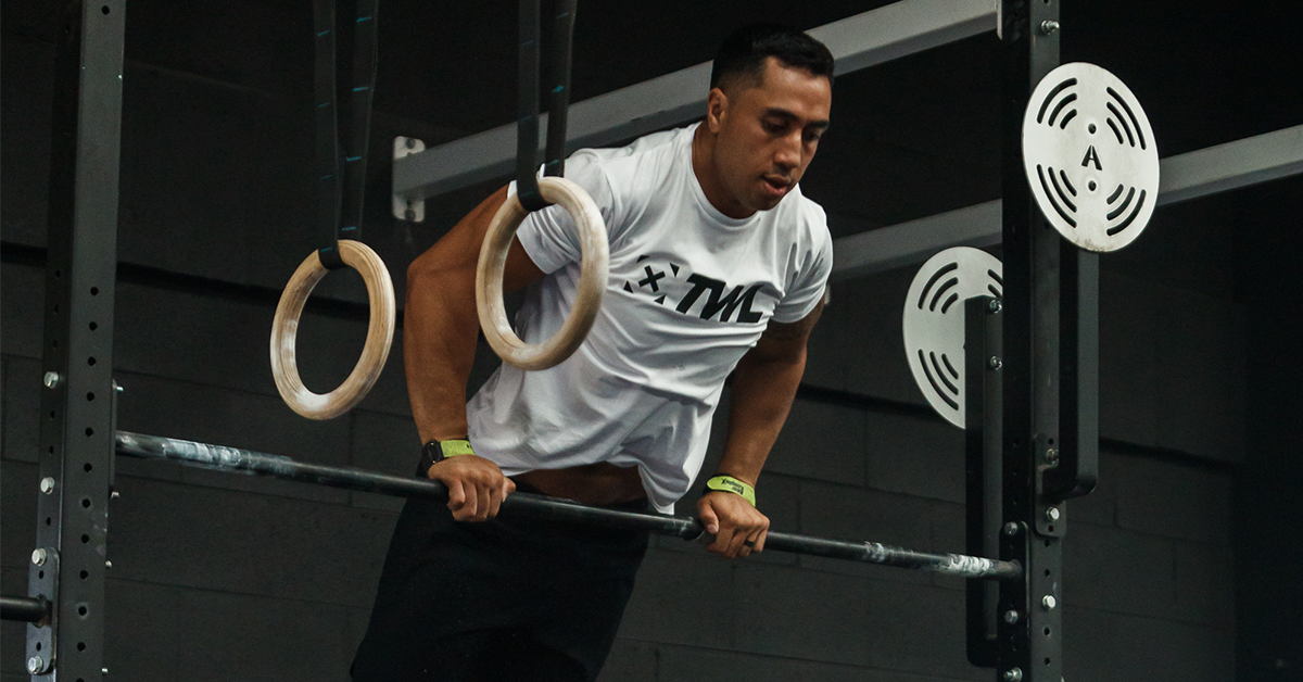 male athlete scaling bar muscle-ups