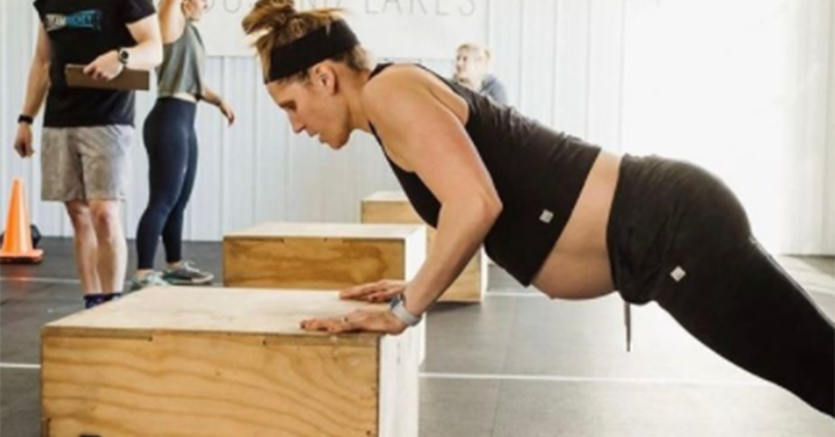 pregnant woman doing push-ups on plyo box