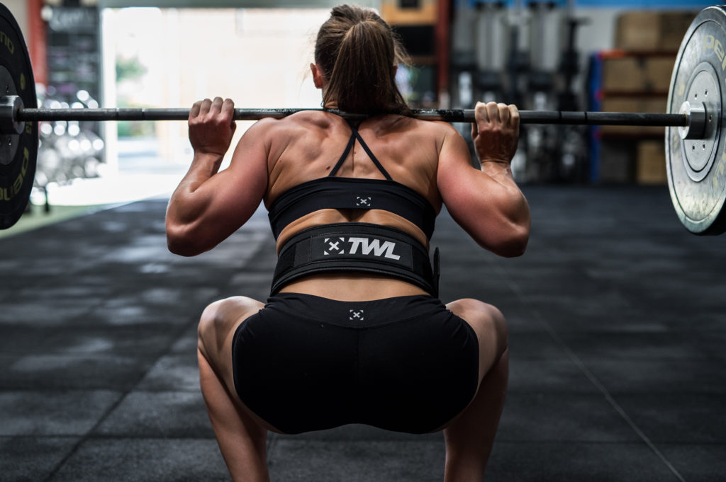 female athlete performing back squat