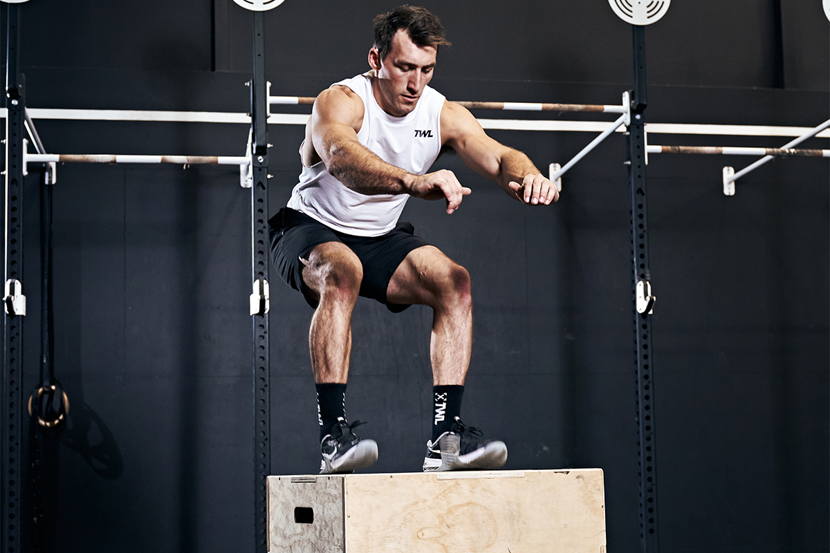 male athlete performing box jumps sets and reps