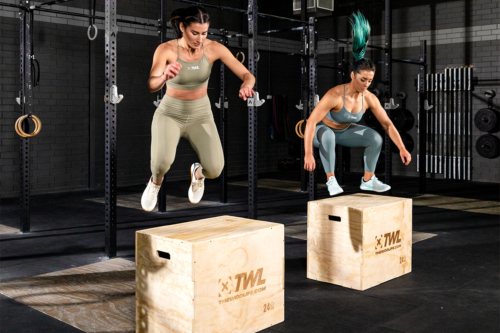 two female athletes doing box jumps