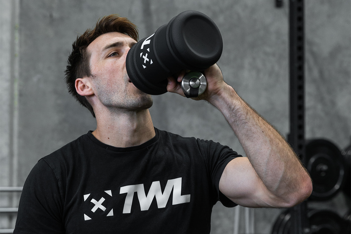 Athlete drinking from The WOD Life water bottle