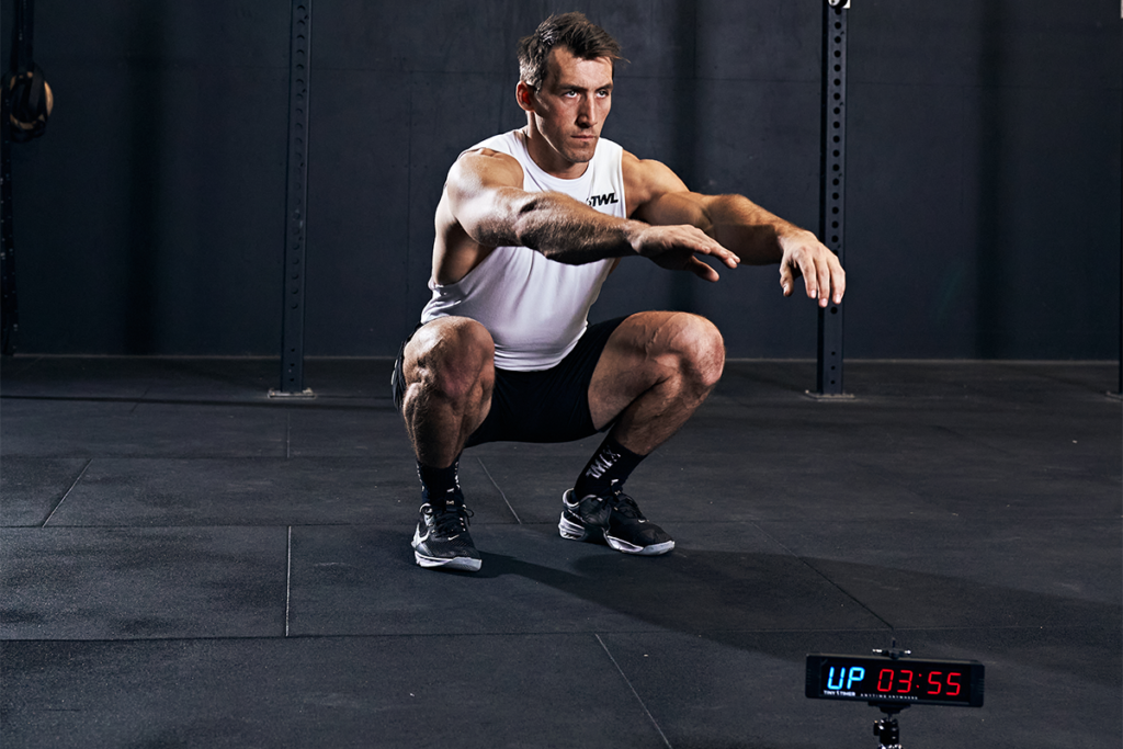 male athlete doing bodyweight air squats to build muscle